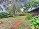 Large backyard with mature trees and a brick walkway at 5001 80Th Avenue E Cir, Sarasota, FL 34243