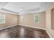 Spacious bedroom featuring hardwood floors, tray ceiling, and ample natural light from multiple windows at 1109 Belcher Rd, Palm Harbor, FL 34683