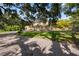Charming home with a beautiful lawn and mature trees, creating a serene outdoor space at 1109 Belcher Rd, Palm Harbor, FL 34683