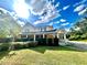 Charming two-story home with a covered entrance, set on a verdant lawn under a sunny sky at 1109 Belcher Rd, Palm Harbor, FL 34683