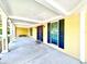 Inviting front porch with columns, ceiling and yellow siding at 1109 Belcher Rd, Palm Harbor, FL 34683