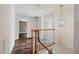 Hallway with hardwood floors, a wooden banister, and decorative lighting fixture at 1109 Belcher Rd, Palm Harbor, FL 34683