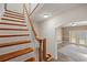 View of the staircase with wooden steps and white risers and a glimpse into the adjacent living area at 1109 Belcher Rd, Palm Harbor, FL 34683