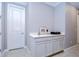 Hallway cabinet with white countertop, drawers, and doors with silver handles, alongside a white door and gray walls at 2406 High Tides Way, Wesley Chapel, FL 33543