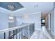 Elegant staircase with wrought iron railing and chandelier, leading to a hallway with views into another room at 2406 High Tides Way, Wesley Chapel, FL 33543