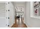 Hallway with hardwood floors leads to a spacious bedroom with tray ceiling, fan, and sitting area at 5621 Rock Dove Dr, Sarasota, FL 34241