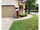 Exterior view of condo with attached garage and landscaped walkway at 10425 La Mirage Ct # 202, Tampa, FL 33615