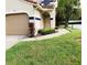Exterior view of condo with attached garage and landscaped walkway at 10425 La Mirage Ct # 202, Tampa, FL 33615