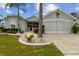 House exterior featuring a screened garage and landscaping at 1119 Villeroy Dr, Sun City Center, FL 33573