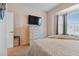 Spacious bedroom with large TV, dresser, and window with curtains at 1119 Villeroy Dr, Sun City Center, FL 33573