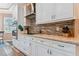 Modern kitchen with white cabinets, tile backsplash, and stainless steel appliances at 1119 Villeroy Dr, Sun City Center, FL 33573