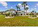 Single-story house with palm trees and well-maintained lawn at 1119 Villeroy Dr, Sun City Center, FL 33573