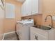 Laundry room with washer, dryer, sink, and cabinets at 1119 Villeroy Dr, Sun City Center, FL 33573