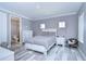 Bright bedroom with a queen bed, white dresser, and grey walls at 2406 High Tides Way, Wesley Chapel, FL 33543