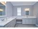 Bathroom with double vanity, quartz countertop, and grey cabinetry at 2406 High Tides Way, Wesley Chapel, FL 33543