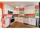 Modern kitchen with white cabinets, granite counters and coral walls at 301 N Glen Ave, Tampa, FL 33609