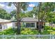 Charming renovated home with a white brick exterior, gray roof, and landscaped lawn at 301 N Glen Ave, Tampa, FL 33609