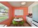 Bright kitchen with white cabinets, coral walls and a breakfast table at 301 N Glen Ave, Tampa, FL 33609