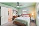 Bedroom with light green walls, wooden bed frame, and en-suite bathroom at 301 N Glen Ave, Tampa, FL 33609