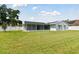 Rear view of house showing screened patio and yard at 8703 Charming Knoll Ct, Tampa, FL 33635