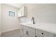 Laundry room with sink, cabinets, and overhead shelving at 2613 Star Apple Way, Sarasota, FL 34240