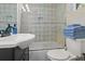 Updated bathroom features a patterned tile shower, white sink vanity, and toilet at 609 N Osceola Ave, Clearwater, FL 33755