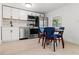 Modern kitchen with white cabinets, stainless steel appliances, and dining area at 609 N Osceola Ave, Clearwater, FL 33755