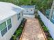 Charming brick-paved backyard pathway, lush landscaping, and detached guest house at 609 N Osceola Ave, Clearwater, FL 33755