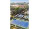 Aerial view of the community tennis court next to the pool and surrounding lush trees at 14506 Alejo Ct, Seminole, FL 33776