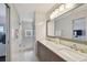 Well lit bathroom featuring double sinks, grey vanity and glass enclosed shower at 4950 Bayshore Blvd # 23, Tampa, FL 33611