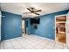 Spacious bedroom with blue walls, tile floors, and a view of the kitchen at 7022 Arbor View Ln, New Port Richey, FL 34653