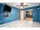 Spacious bedroom with blue walls, tile floors, and access to another room at 7022 Arbor View Ln, New Port Richey, FL 34653