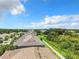 Aerial view showcasing a row of townhouses with a green space and lake beyond at 11650 Cambium Crown Dr, Riverview, FL 33569