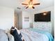 Comfortable bedroom with a ceiling fan, dresser, and large TV at 11650 Cambium Crown Dr, Riverview, FL 33569
