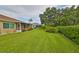 Large backyard with a grassy area and hedges at 736 Mccallister Ave, Sun City Center, FL 33573