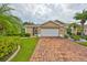 Tan one-story home with brick driveway and landscaping at 736 Mccallister Ave, Sun City Center, FL 33573
