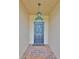 Inviting entryway with a dark blue door and terracotta tile floor at 736 Mccallister Ave, Sun City Center, FL 33573