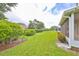 Backyard view showing a grassy area, hedges, and part of the house at 736 Mccallister Ave, Sun City Center, FL 33573