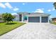 Contemporary home with a three-car garage and elegant paved driveway in a well-manicured yard at 5217 Forbes Ter, Port Charlotte, FL 33981