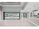 Open floorplan with a kitchen bar overlooking the living room and a view of the pool through sliding doors at 5217 Forbes Ter, Port Charlotte, FL 33981