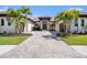 Stunning exterior view of a luxury home with lush landscaping, tile roof, and an inviting circular driveway at 9276 Starry Night Ave, Sarasota, FL 34241