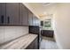 Well-lit laundry room with dark wood cabinets, granite countertops, and modern washer and dryer at 9276 Starry Night Ave, Sarasota, FL 34241