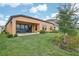 Landscaped backyard with a covered patio and a large grassy area at 12818 Boggy Creek Dr, Riverview, FL 33579