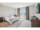Main bedroom with a king-size bed, large windows with lake view, and a dresser at 12818 Boggy Creek Dr, Riverview, FL 33579
