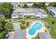 Aerial view of community pool, shuffleboard courts, and building exteriors at 1655 S Highland Ave # E223, Clearwater, FL 33756