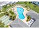 Community pool with surrounding patio furniture and shuffleboard courts at 1655 S Highland Ave # E223, Clearwater, FL 33756