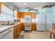 Kitchen with light wood cabinets, white appliances, and ample counter space at 11314 Misty Isle Ln, Riverview, FL 33579