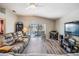 Spacious living room featuring a comfy sofa, large TV, and sliding glass doors leading to the backyard at 11314 Misty Isle Ln, Riverview, FL 33579