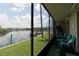 Enjoy waterfront views from this screened porch with teal chairs at 8818 Bay Pointe Dr # 108, Tampa, FL 33615