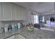 Kitchen counter with granite top, pass-through to living area, and fruit bowl at 8818 Bay Pointe Dr # 108, Tampa, FL 33615